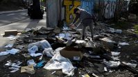 TV reporter takes photos of the mess created with the remains of items stolen from passing freight trains, in Los Angeles
