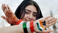 A student poses for a photo after painting the National flag on her hand